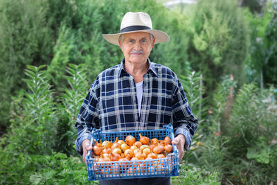 Portrait of man holding fruits in basket