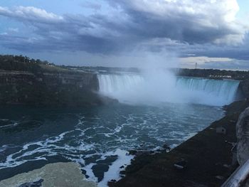 Scenic view of waterfall against sky