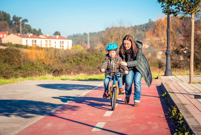 Woman riding bicycle on road in city
