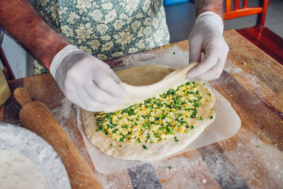 Midsection of person preparing food at table