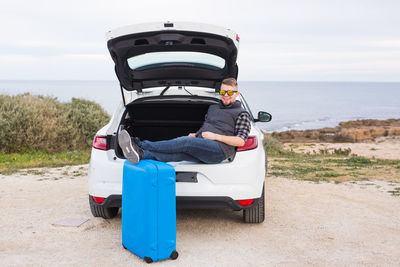 Rear view of man on beach against sky