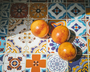 Oranges on a colourful ceramic table, under the sun