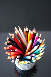 Close-up of multi colored pencils on table in case on table