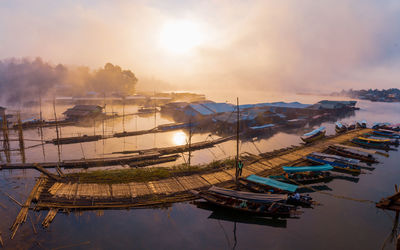 High angle view of fishing boats moored in lake against sky during sunset