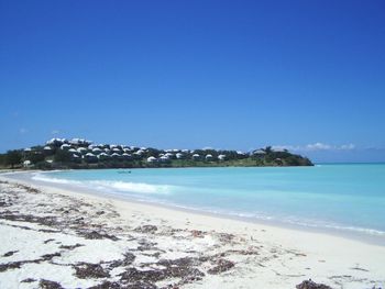 Scenic view of beach against clear blue sky