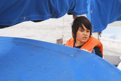 Boy sailing boat in sea