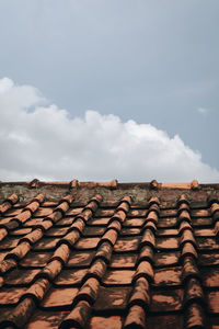 Low angle view of roof tiles against sky