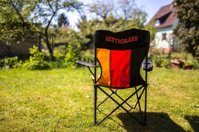 Chair on field against sky