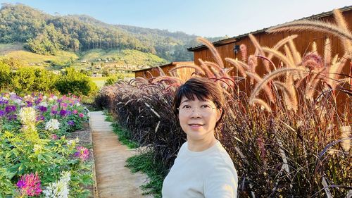 Portrait of young woman standing against mountain