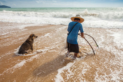 Man fishing with dog at beach