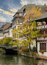 Buildings by river against built structures