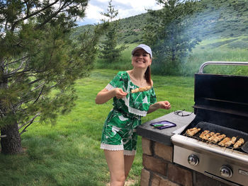 Smiling man standing on barbecue grill