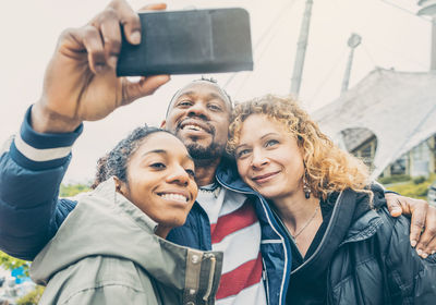 Portrait of smiling young woman using mobile phone