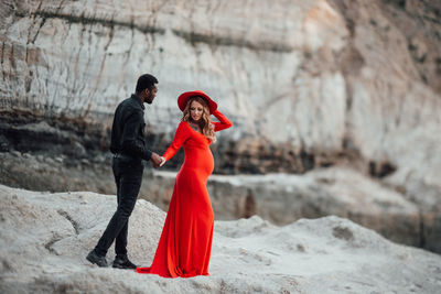 Woman with red standing against blurred background