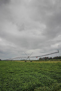 View of grassy field against cloudy sky