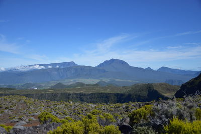 Scenic view of mountains against blue sky