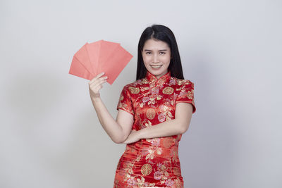 Portrait of a smiling young woman against white background