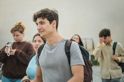 Young man with backpack walking on street