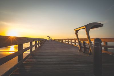 Pier on sea at sunset