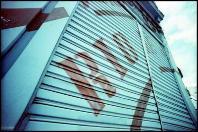 Low angle view of text on building against sky