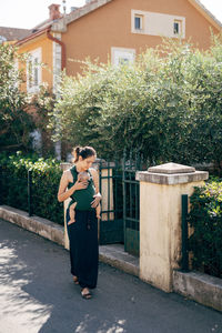 Full length of woman standing by building