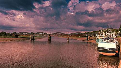 Bridge over river against sky during sunset