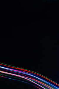 Light trails on road against sky at night