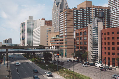 Vehicles on road in city against sky