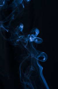 Close-up of blue smoke against black background