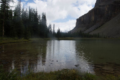 Scenic view of lake by mountains against sky