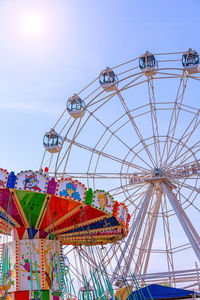 Low angle view of ferris wheel against blue sky