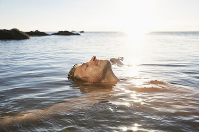 Relaxed mature man floating in the sea