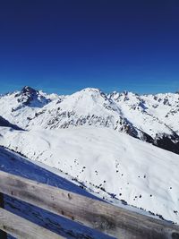 Scenic view of snowcapped mountains against clear blue sky