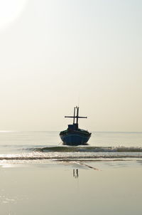 Sailboat in sea against clear sky during sunset