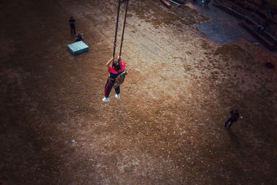 High angle view of girl bungee jumping over land