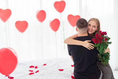 Woman with red balloons at home