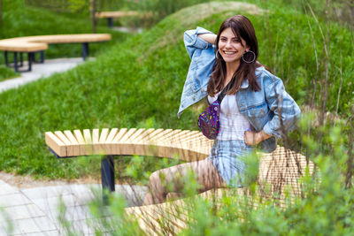 Full length of a smiling young woman standing outdoors