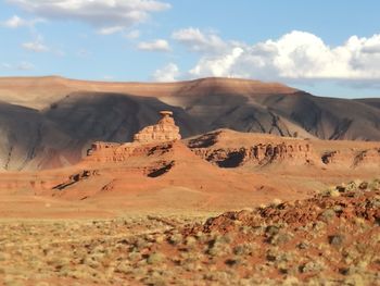 Scenic view of desert against cloudy sky