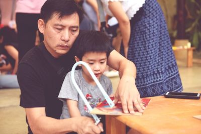 Father and son doing artwork in home