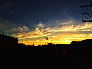 Silhouette of buildings against sky during sunset