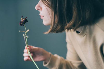 Portrait of woman holding flowering plant