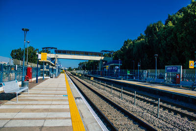 Railroad station platform against clear blue sky