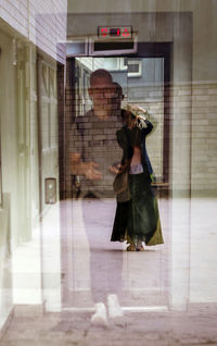 Woman photographing with reflection on glass