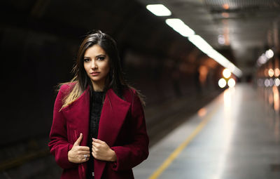 Portrait of beautiful woman standing at railway station