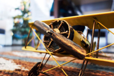 Close-up of a miniature yellow biplane symbolizing flying and traveling