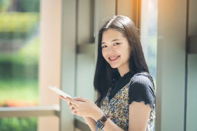 Portrait of smiling woman using mobile phone