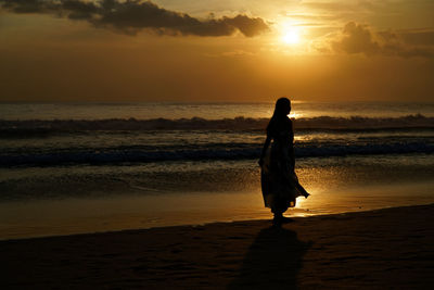 Silhouette woman on beach during sunset