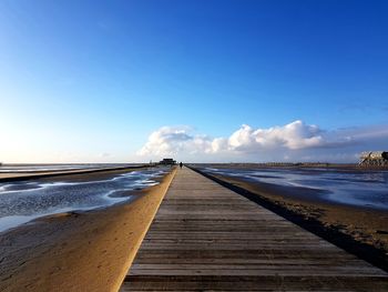 Scenic view of beach against blue sky