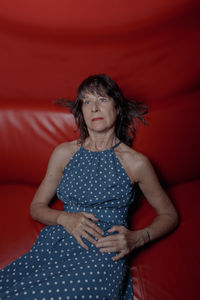 Portrait of young woman sitting on bed at home