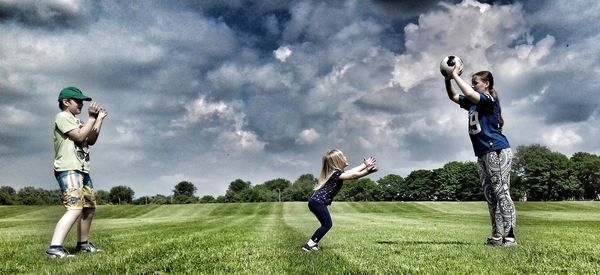 Full length of young woman standing on field against sky